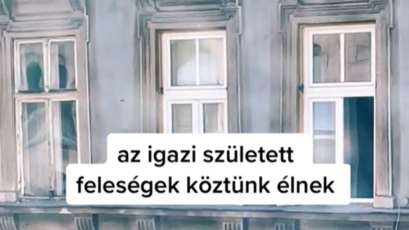 egy nő ablakot pucol egy emeleti lakás párkányáról védőfelszerelés nélkül Budapesten 2023 márciusában 