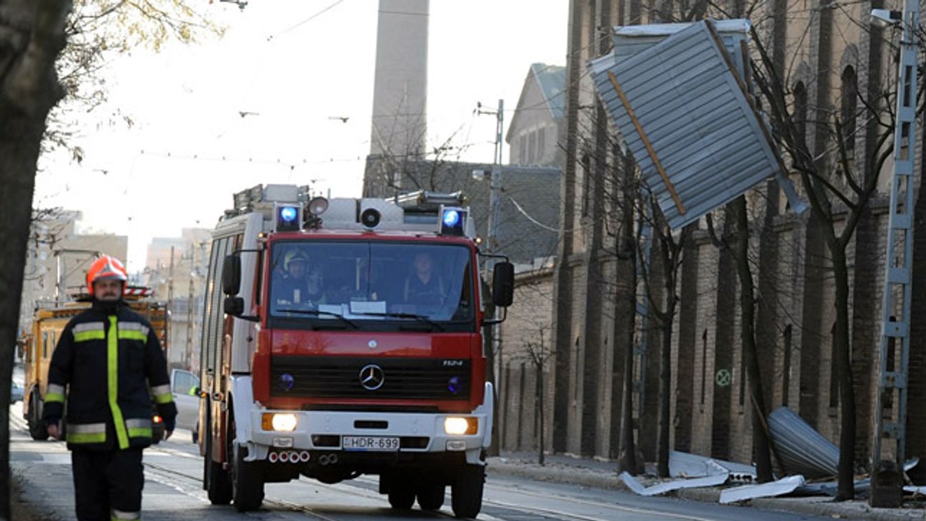 viharkár. Raktárépület tetőszerkezetének elemei, amelyeket a viharos szél szakított le Budapesten, a Gubacsi úton