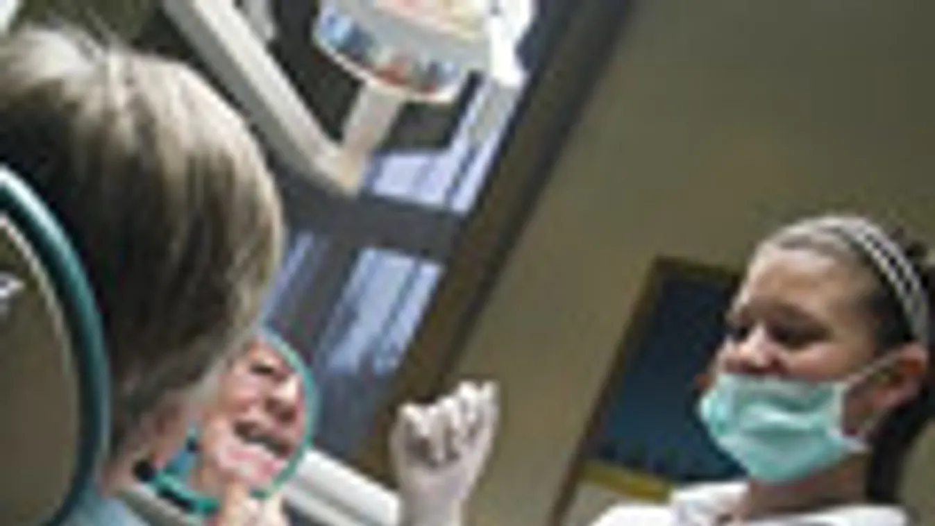 fogászati turizmus, állami pályázat, Rosa Manzl osztrák páciens tükörben nézi fogait Ebedli Ivett fogorvos (j) rendelőjében a mosonmagyaróvári Diamant-Dent Fogegészségügyi Intézetben.