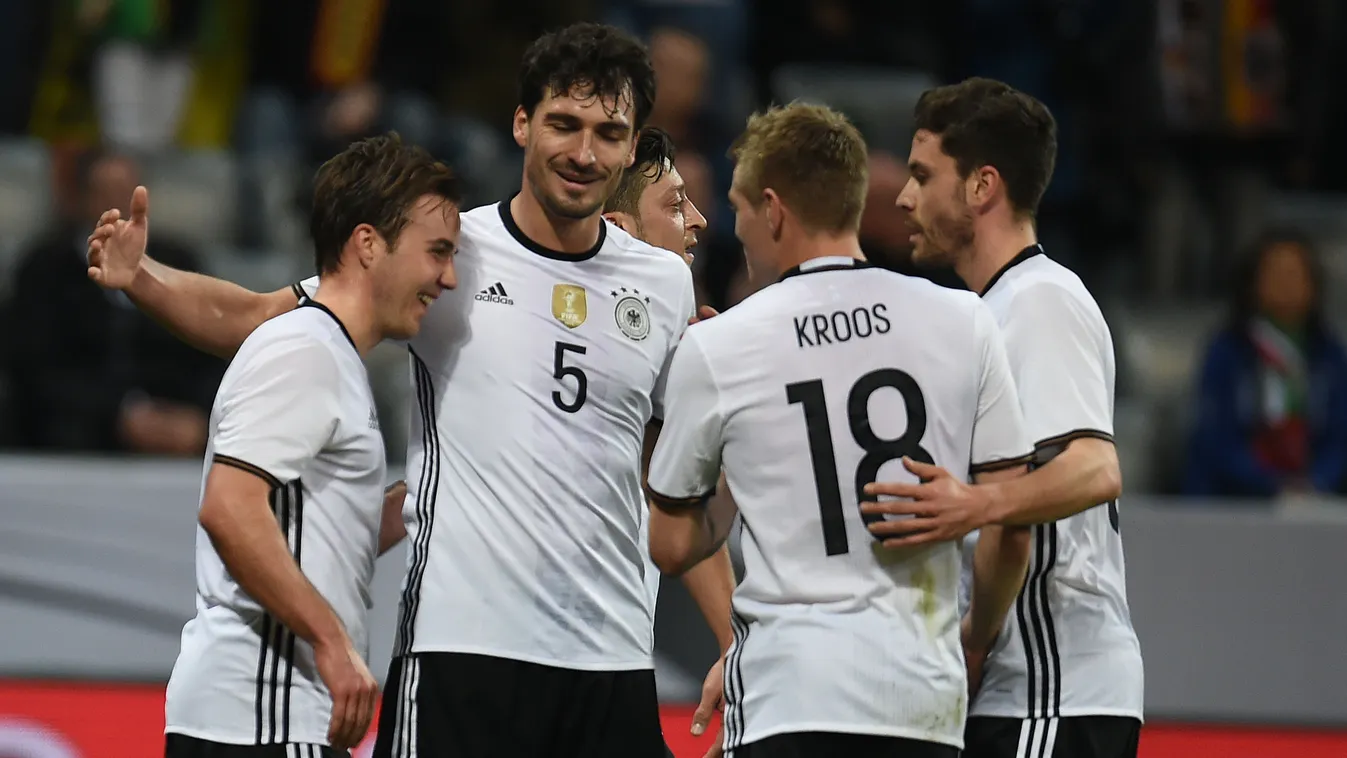 Germany's forward Mario Goetze (L) reacts with teammates defender Mats Hummels (C) and midfielder Toni Kroos after scoring during the friendly football match Germany vs Italy in Munich, southern Germany on March 29, 2016. 
PATRIK STOLLARZ / AFP 