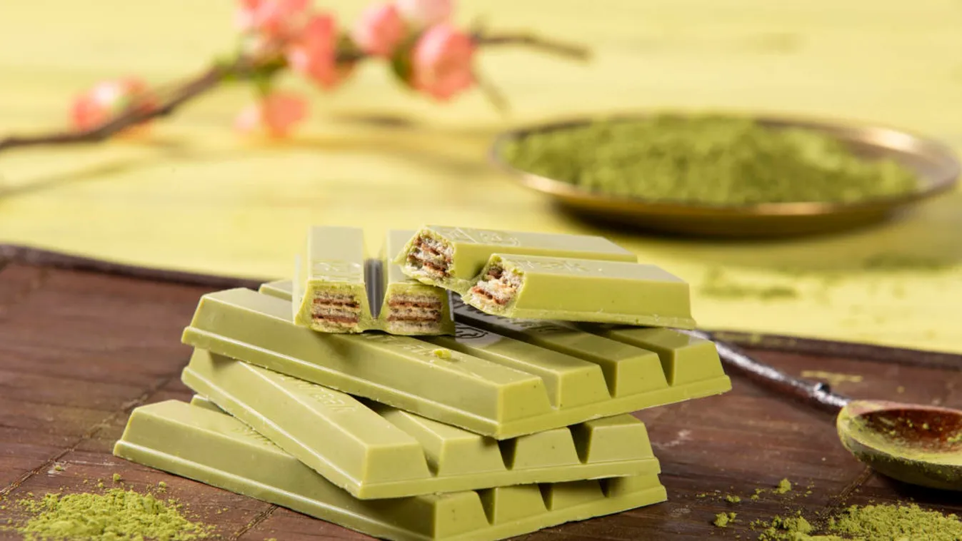 Beauty Photography: KitKat Matcha stacked together, Upper tier spilt in half, placed on a wooden mat with matcha powder and tea spoon 
