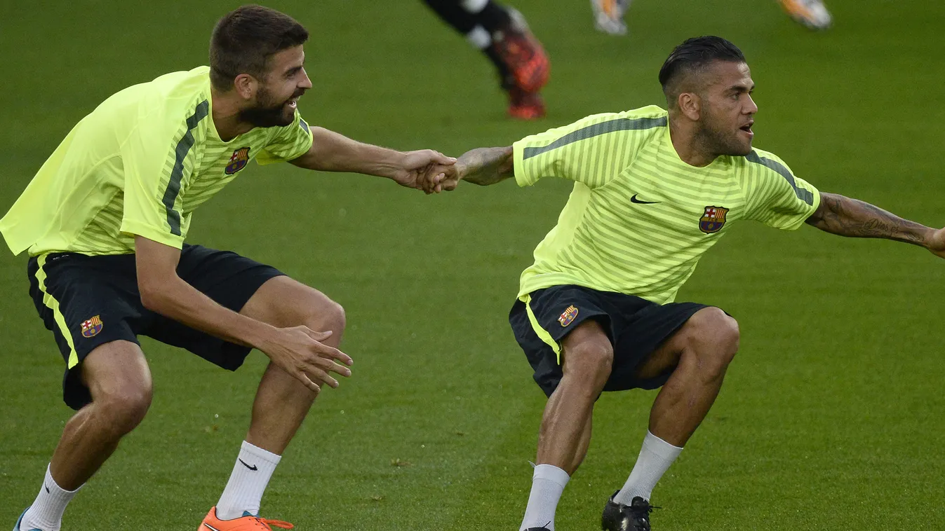 - Barcelona's defender Gerard Pique (L) runs with Barcelona's Brazilian defender Dani Alves during a training session at the Parc des Princes stadium in Paris on September 29, 2014, on the eve of their UEFA Champions League football match against Paris. 