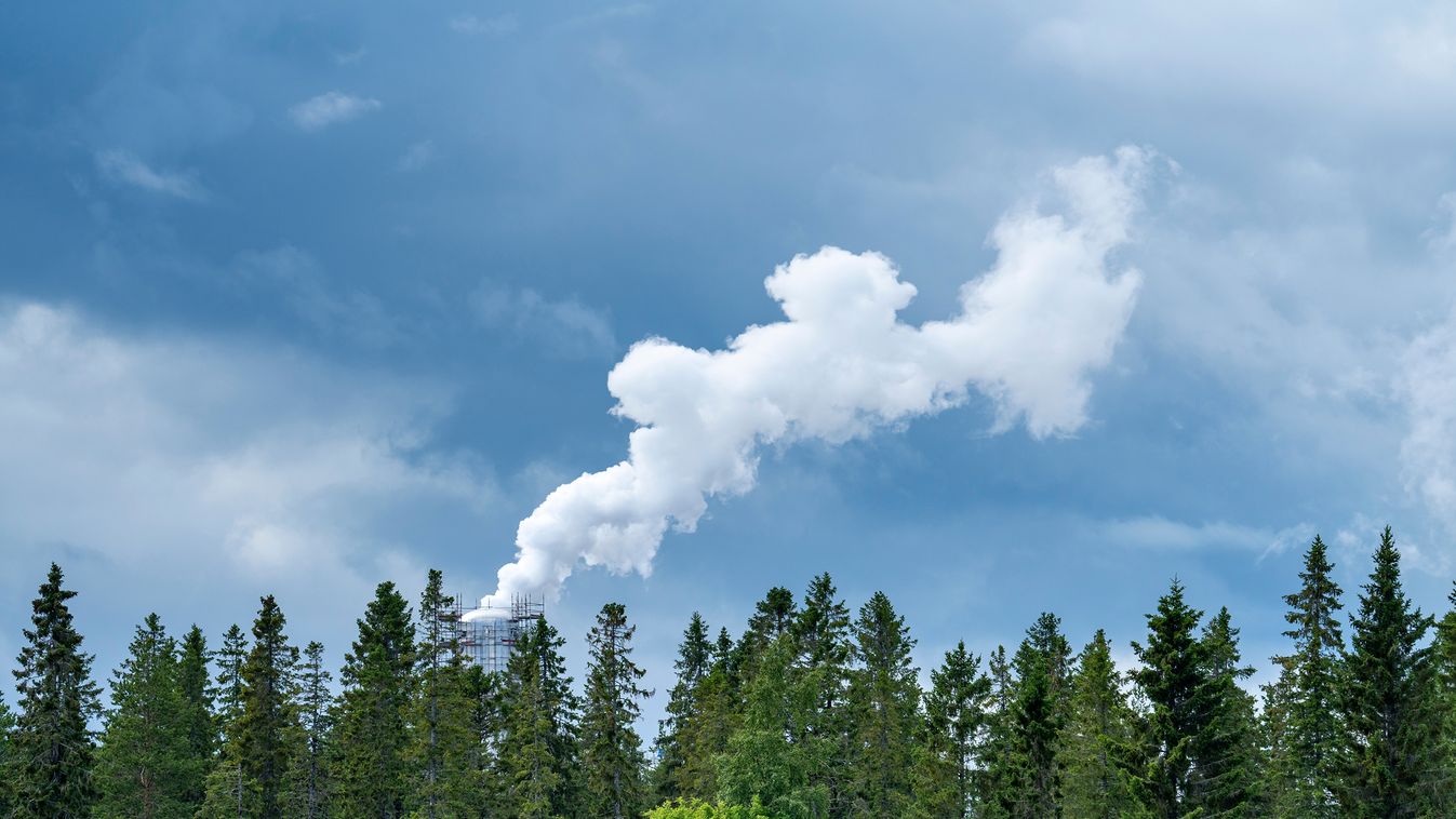 Smoke plume from industry emitting greenhouse gas into the atmosphere on forest trees background and blue cloudy sky. Philip Morris 