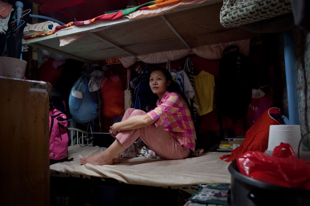 Horizontal Cubicle home resident surname Lau sits in the room she shares with two other family members, in Hong Kong on May 20, 2011. Amid rising inflation many cage or cubicle home dwellers risk being subjected to rent increases despite paying a similar 
