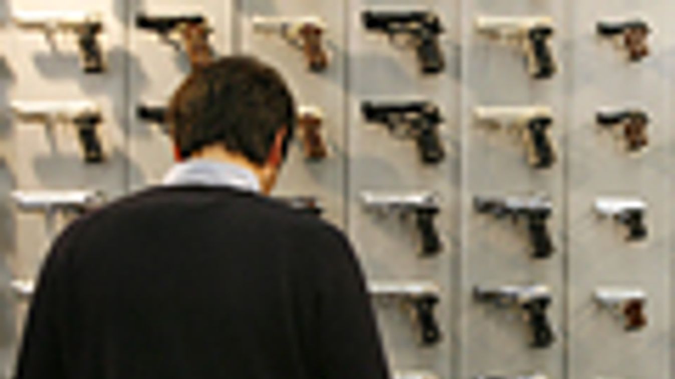 fegyver, fegyvertartás Amerikában, fegyverviselés, egy férfi pisztolyokat vizsgál egy németországi fegyvervásáron