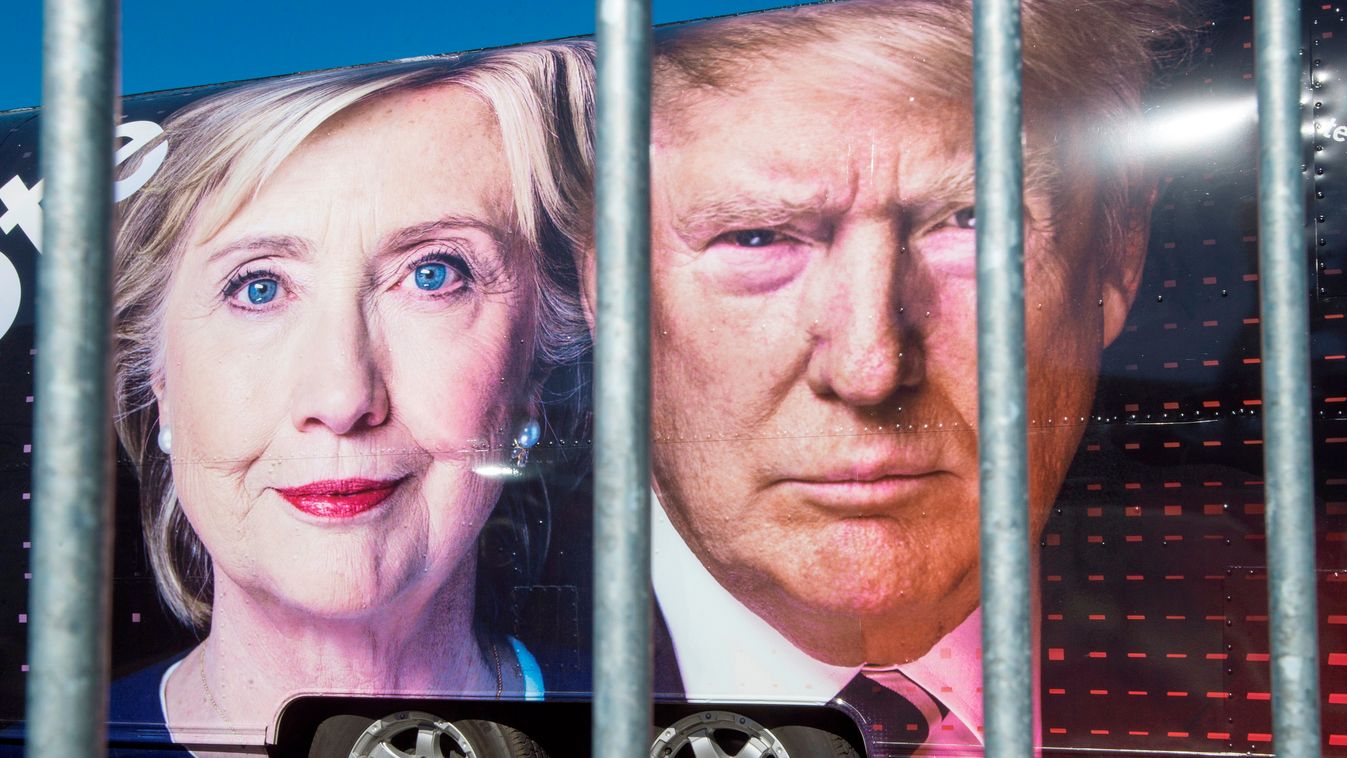 TOPSHOTS Horizontal Large images of Democratic nominee Hillary Clinton and Republican nominee Donald Trump are seen on a CNN vehicle, behind asecurity fence, on September 24, 2014, at Hofstra University, in Hempsted, New York.
The university is the site o