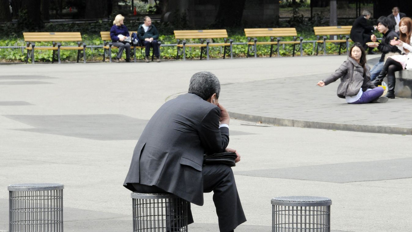 japán gazdaság, spórolás, egy üzletember ül egy tokiói parkban