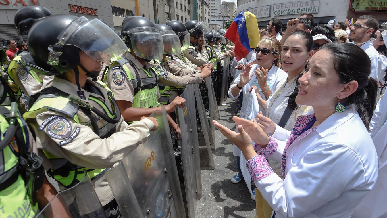 Horizontal Doctors chant slogans in front of a line of National Guard personnel in riot gear during a demonstration against the shortage in medicines and in rejection of the government of President Nicolas Maduro, in Caracas on May , 17, 2017.
Venezuela's