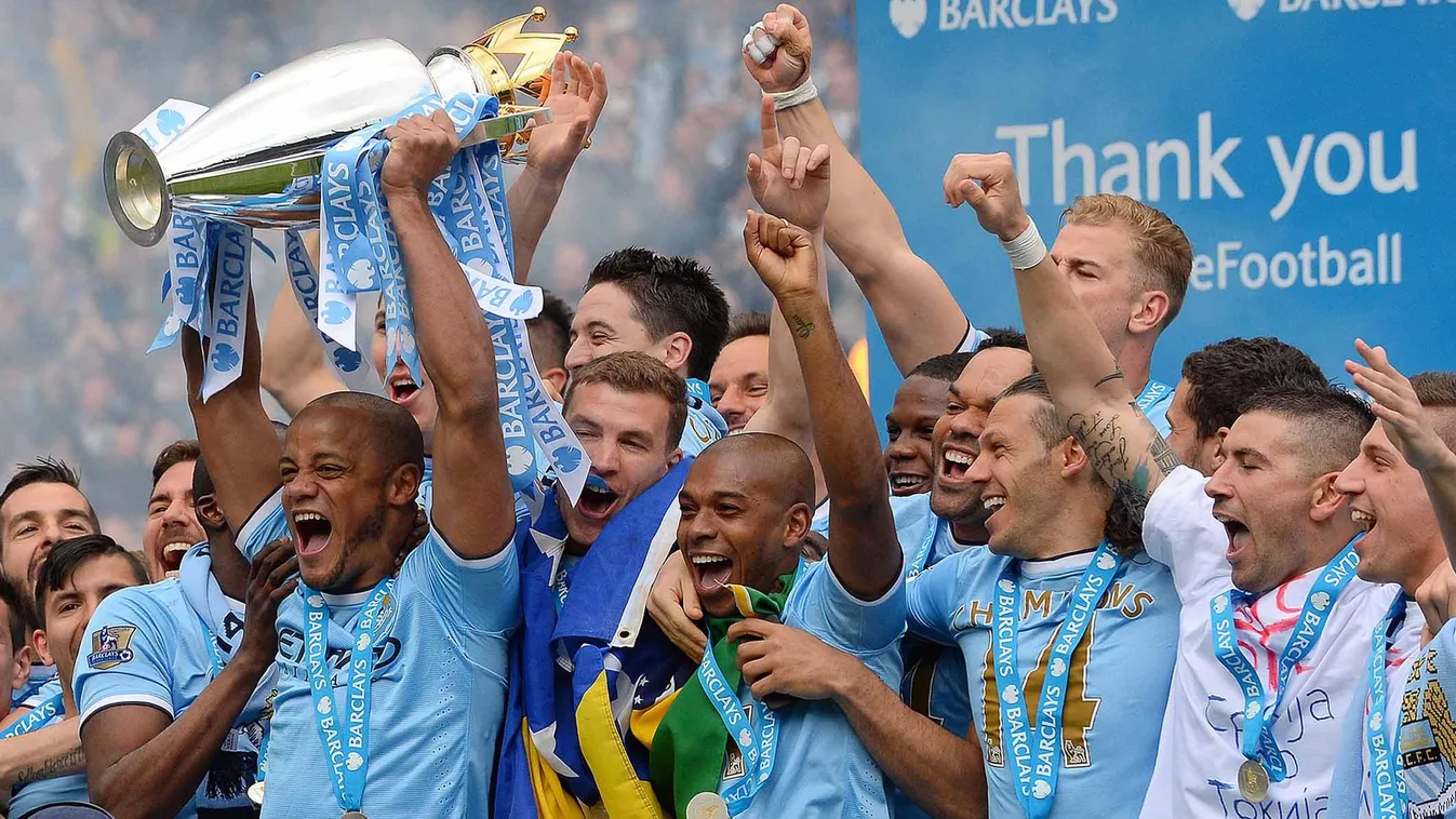170612797 Manchester City's Belgian midfielder Vincent Kompany celebrates with the trophy after his team won the Premiership title following their victory in the English Premier League football match between Manchester City and West Ham United at the Etih