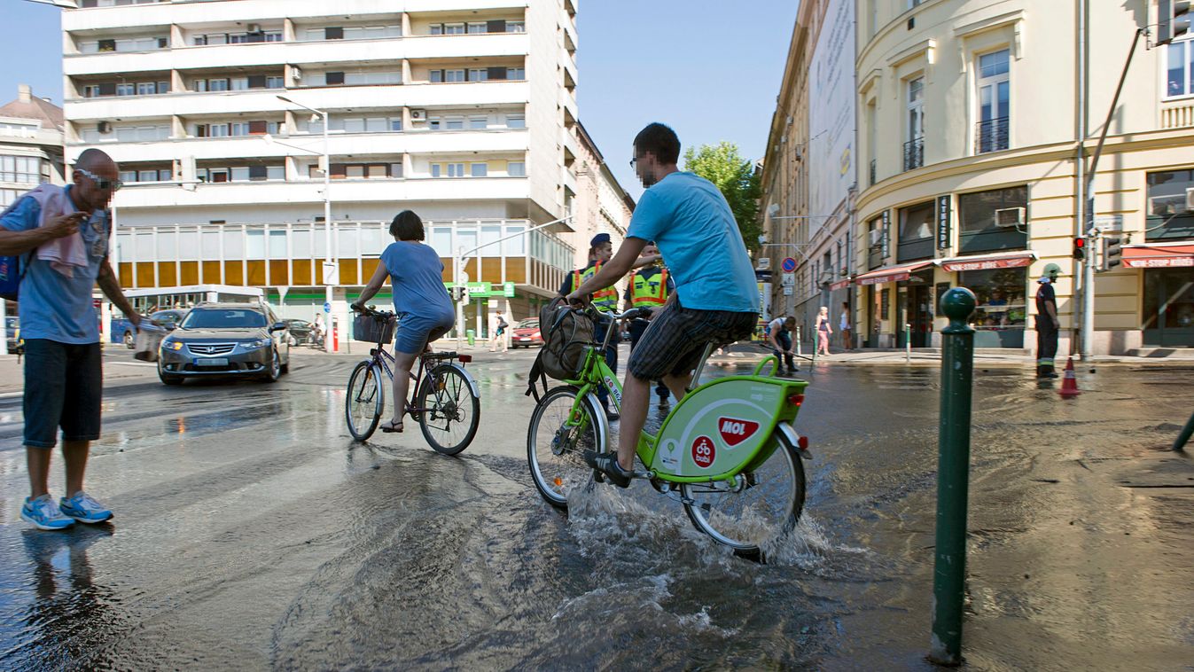Budapest, 2015. július 22.
Kerékpárosok az Attila út és az Alagút utca találkozásánál, ahol eltörött egy nagyobb víznyomócső 2015. július 22-én.
MTI Fotó: Lakatos Péter 