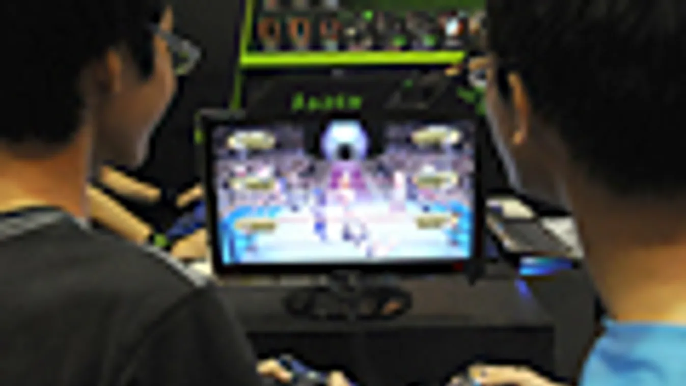 két fiatal Xbox 360-on játszik egy szingapuri techvásáron 