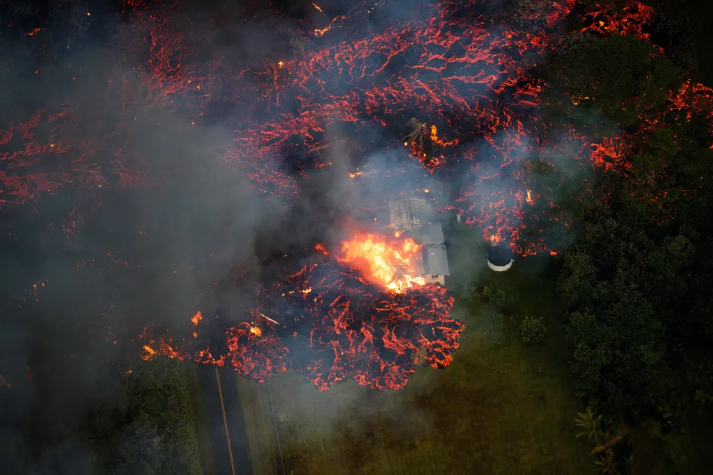 Pahoa, 2018. május 7.
A Kilauea tűzhányó lávája ömlik ki egy repedésből a hawaii Paho Leilani lakónegyedében 2018. május 6-án. A vulkánkitörés mintegy harminc házat elpusztított és csaknem kétezer embert otthonának elhagyására kényszerített. (MTI/EPA/Para