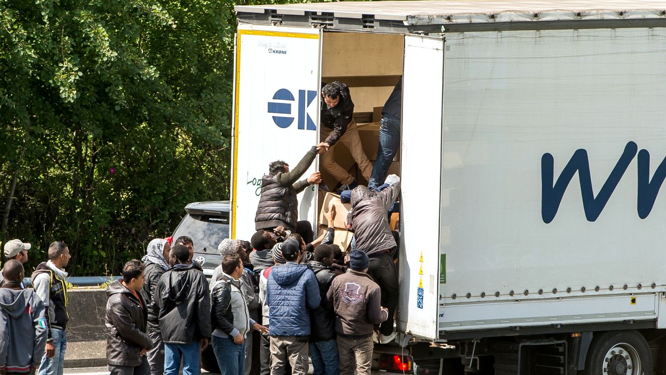 HORIZONTAL IMMIGRATION MIGRATION AND IMMIGRATION IMMIGRANT REFUGEE ILLEGAL IMMIGRANT MOTORWAY LORRY TRANSPORT Migrants climb in the back of a lorry on the A16 highway leading to the Eurotunnel on June 23, 2015 in Calais, northern France. Some of the thous