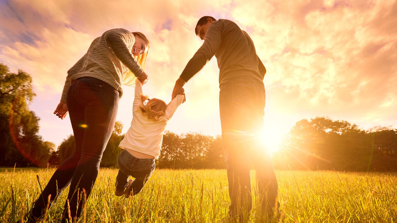 Parents hold baby's hands.  Happy family in park evening Two Parents Beautiful Baby Girls Girls Women Men Males Group Of People Beauty In Nature Lighting Equipment Adoption Grass Dawn Cute Young Adult Child Smiling Beauty Healthy Lifestyle Caucasian Ethni