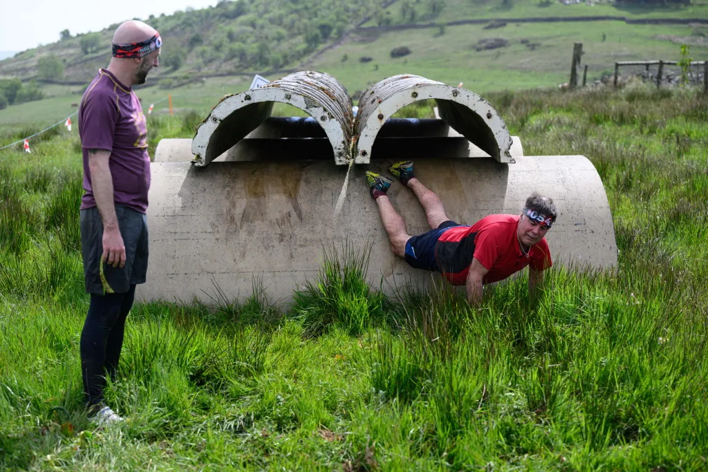 Horizontal OFFBEAT SPORTS EVENT MUD RACE GAMES AND RECREATION Competitors take part in the Bog Commander endurance event near Ashbourne, in the Peak District moorlands, in northern England, on May 14, 2022. - The Bog Commander is a muddy obstacle race of 