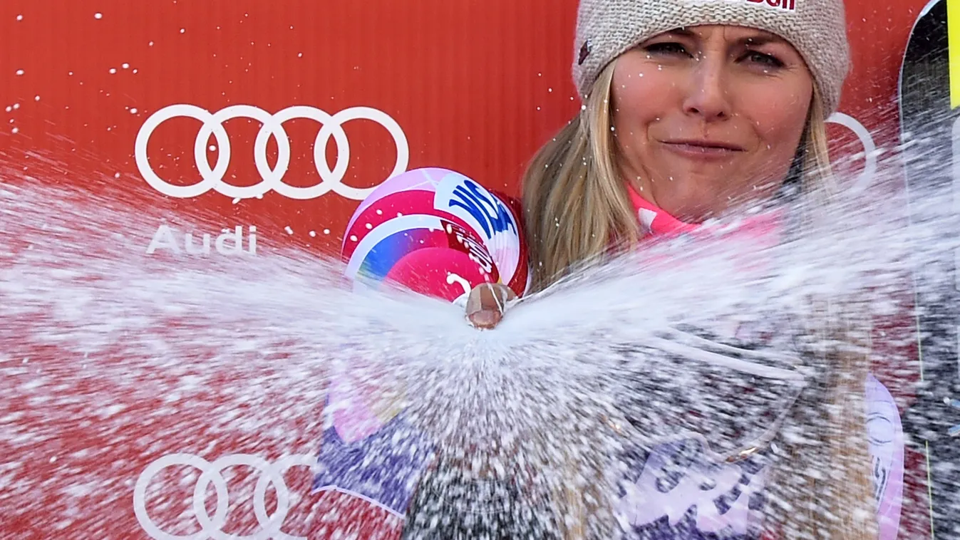 US Lindsey Vonn sprays champagne as she celebrates her gold medal during the podium ceremony after winning  the FIS Alpine World Cup Women's Downhill on December 20, 2014 in Val d'Isere, French Alps. US Lindsey Vonn won the event as Austria's Elisabeth Go