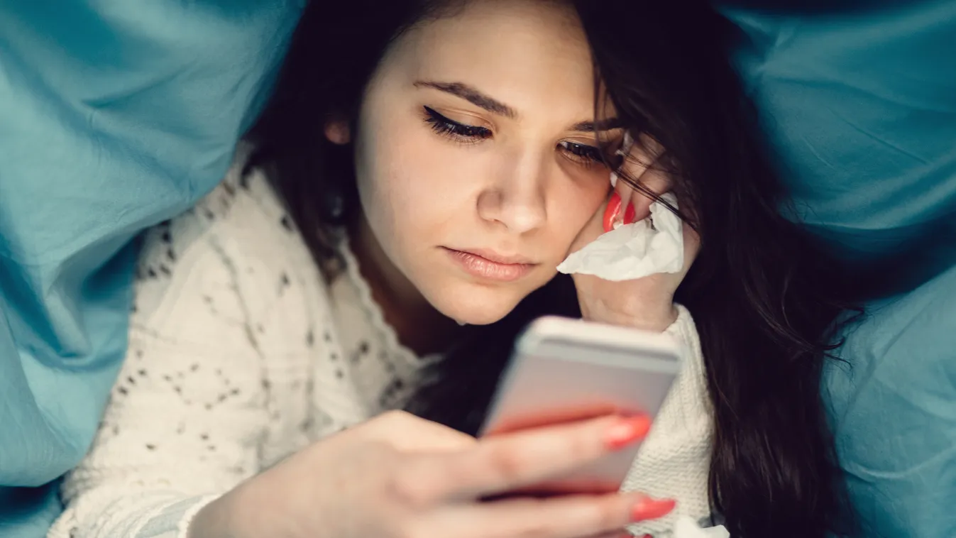 Crying girl in bed texting on smartphone Smart Phone Using Phone Text Messaging Relationship Difficulties Teenage Girls Young Women Women Females Surfing the Net Domestic Life Young Adult Typing Crying One Person Frustration Failure Sadness Grief Depressi