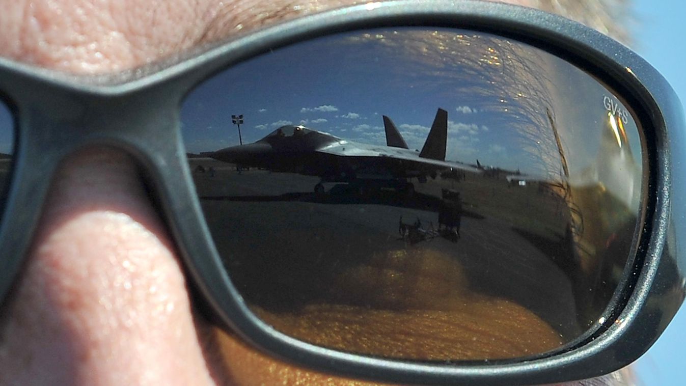 A US Air Force F-22 Raptor is reflected in the sunglasses of Lt Col Jeff Hawkins of the 94th Fighter Squadron during the Australian International Airshow in Melbourne on March 1, 2013. 180,000 patrons are expected through the gates over the duration of th