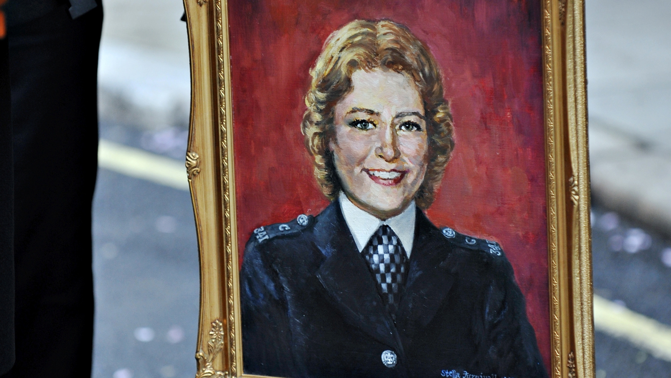 Vertical A Police officer holds a portrait of the late PC Yvonne Fletcher before a ceremony to mark the 25th anniversary of her death in St. James Square, in London, on April 17, 2009. PC Yvonne Fletcher was murdered while policing a protest by Libyan dis