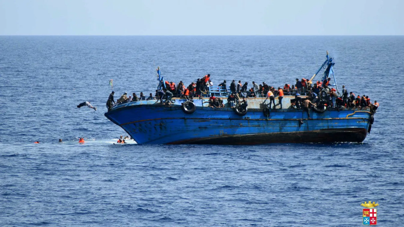 Líbia, 2016. május 25.
Az olasz haditengerészet által közreadott felvételen migránsok ugrálnak a tengerbe egy megbillent hajó fedélzetéről Líbia partjainál 2016. május 25-én. Az elmúlt egy napban a mentést irányító olasz haditengerészet egyéb hajók közrem