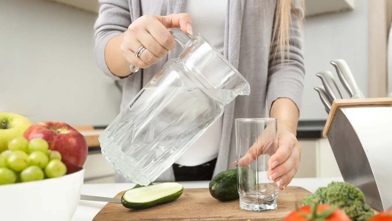 Closeup of woman pouring water in glass on kitchen Purified Water Healthy Eating Stereotypical Housewife Women Kitchenware Department Drinking Glass Cooking Pouring Freshness Nature Indoors Close-up Tomato Lettuce Vegetable Domestic Kitchen Home Interior 