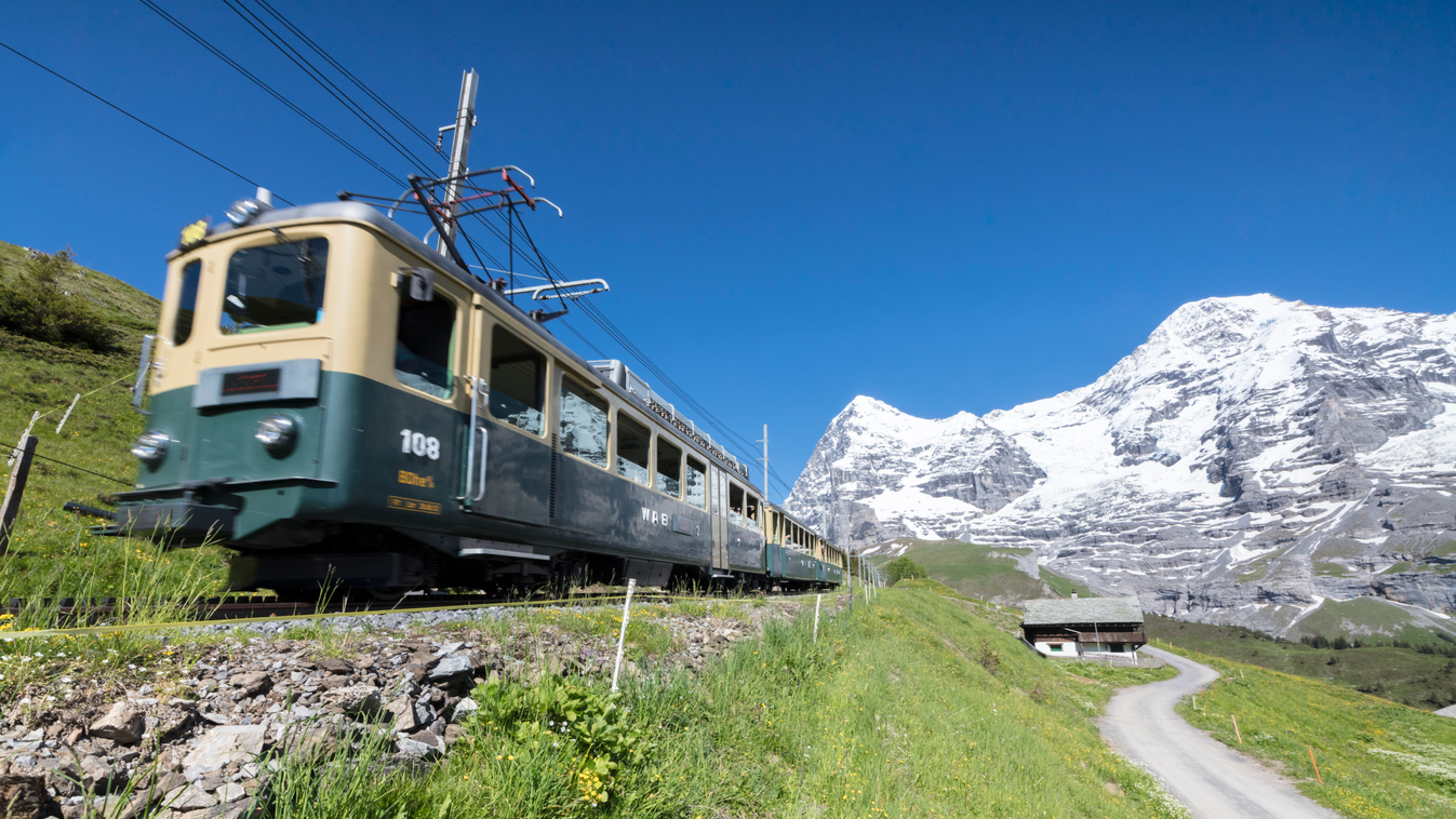 The Wengernalpbahn rack railway runs across meadows and snowy peaks, Wengen, Bernese Oberland, Canton of Bern, Switzerland, Europe photography colour colour image COLOR color image HORIZONTAL horizontal image outdoors outside day nobody no one no-one trav