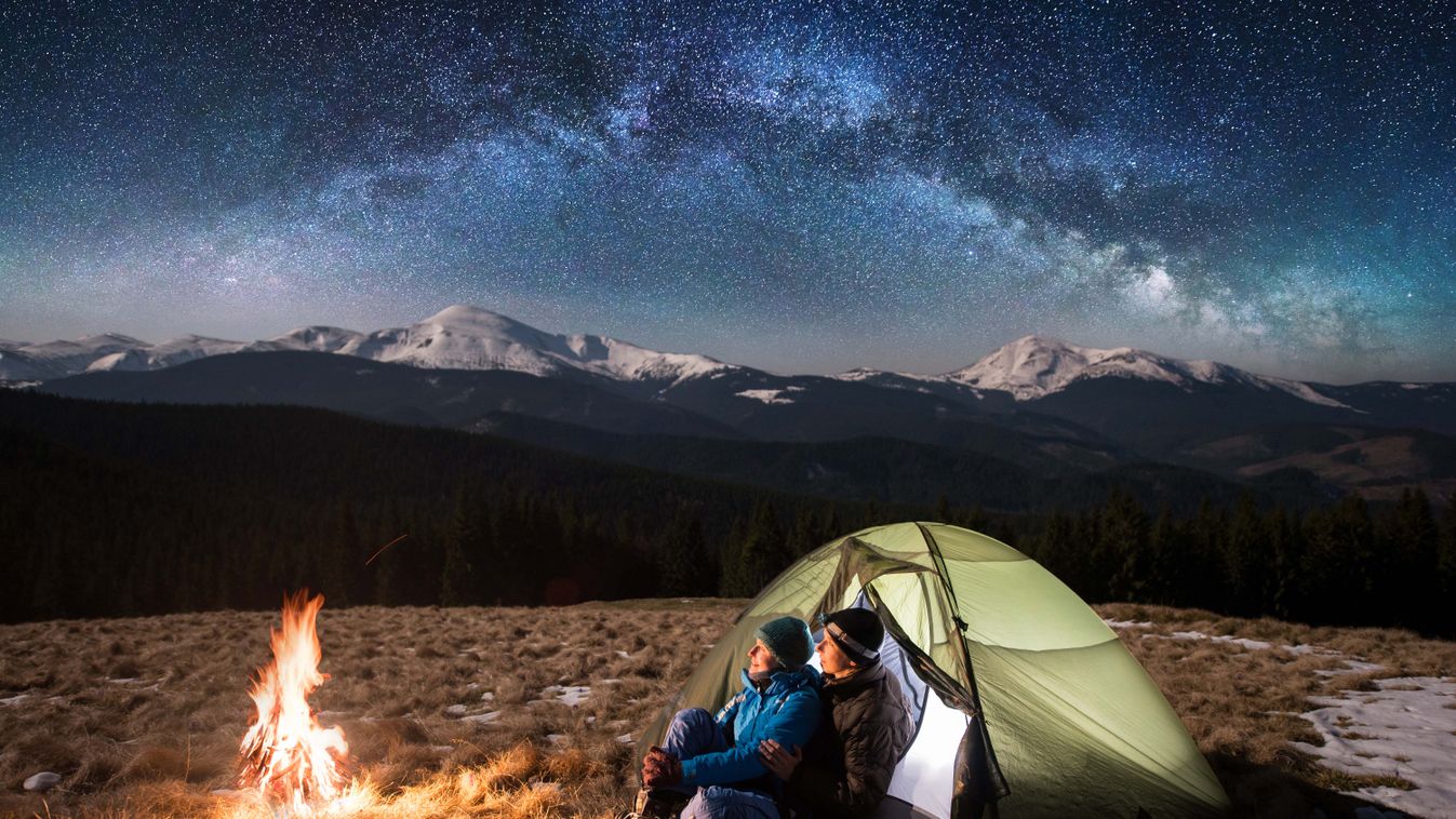 az emberek túrázás közben  Having camping,couple,happy,space,milky,trip,camper,campfire,sky,astrop Young couple tourists enjoying in the camping at night, having a rest near campfire and green tent under beautiful 