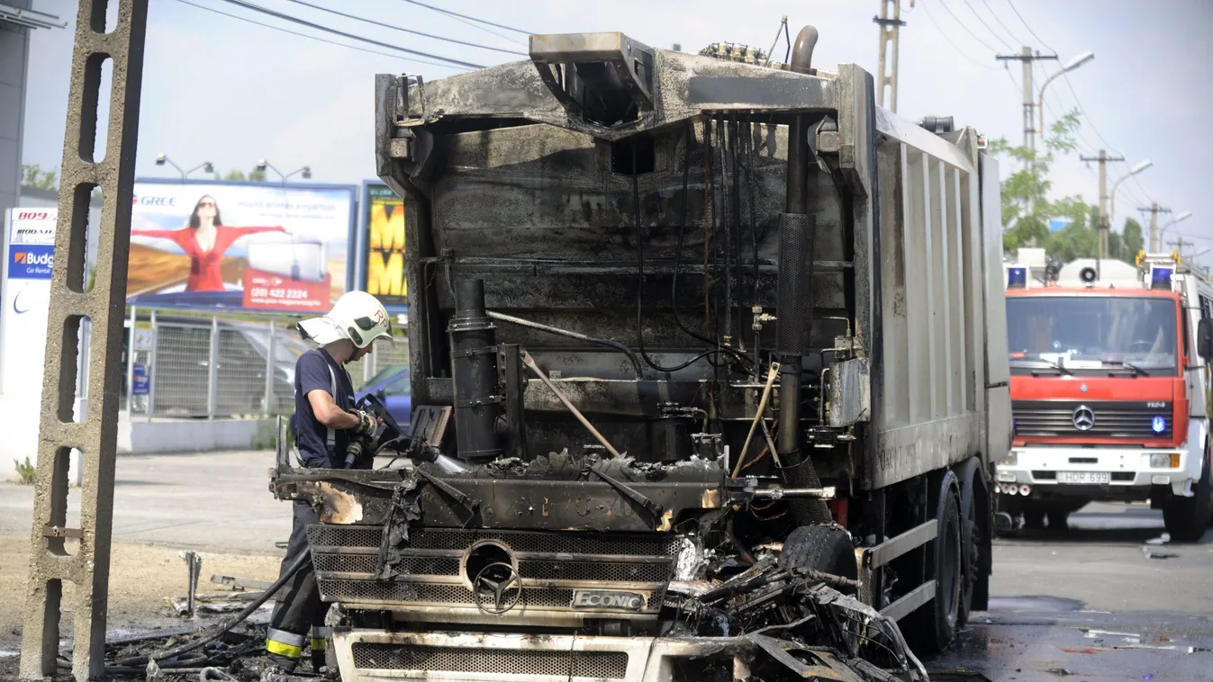 Budapest, 2015. június 8.
Tűzoltó dolgozik egy kiégett kukásautó mellett a fővárosi Üllői úton, Vecsés határánál 2015. június 8-án. A tűz a kukásautó vezetőfülkéjében keletkezett, a lángok átterjedtek a jármű szeméttároló részére is. Senki sem sérült meg,
