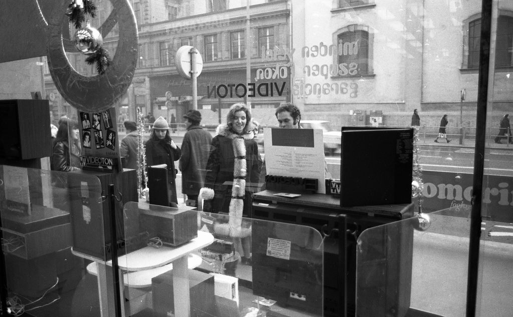 LEÍRÁS
Magyarország,
Budapest V.
Kossuth Lajos utca 2/b, Keravill üzlet (Videoton márkabolt) kirakata belülről, szemben a Belvárosi Ferences Templom oldala. 1975 