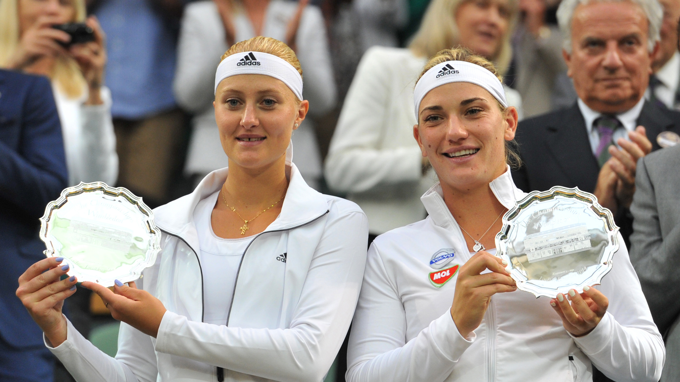Timea Babos (R) and France's Kristina Mladenovic hold their runners'-up trophies after losing their women's doubles final match to Italy's Sara Errani and Roberta Vinci on day twelve of the 2014 Wimbledon Championships at The All England Tennis Club in Wi