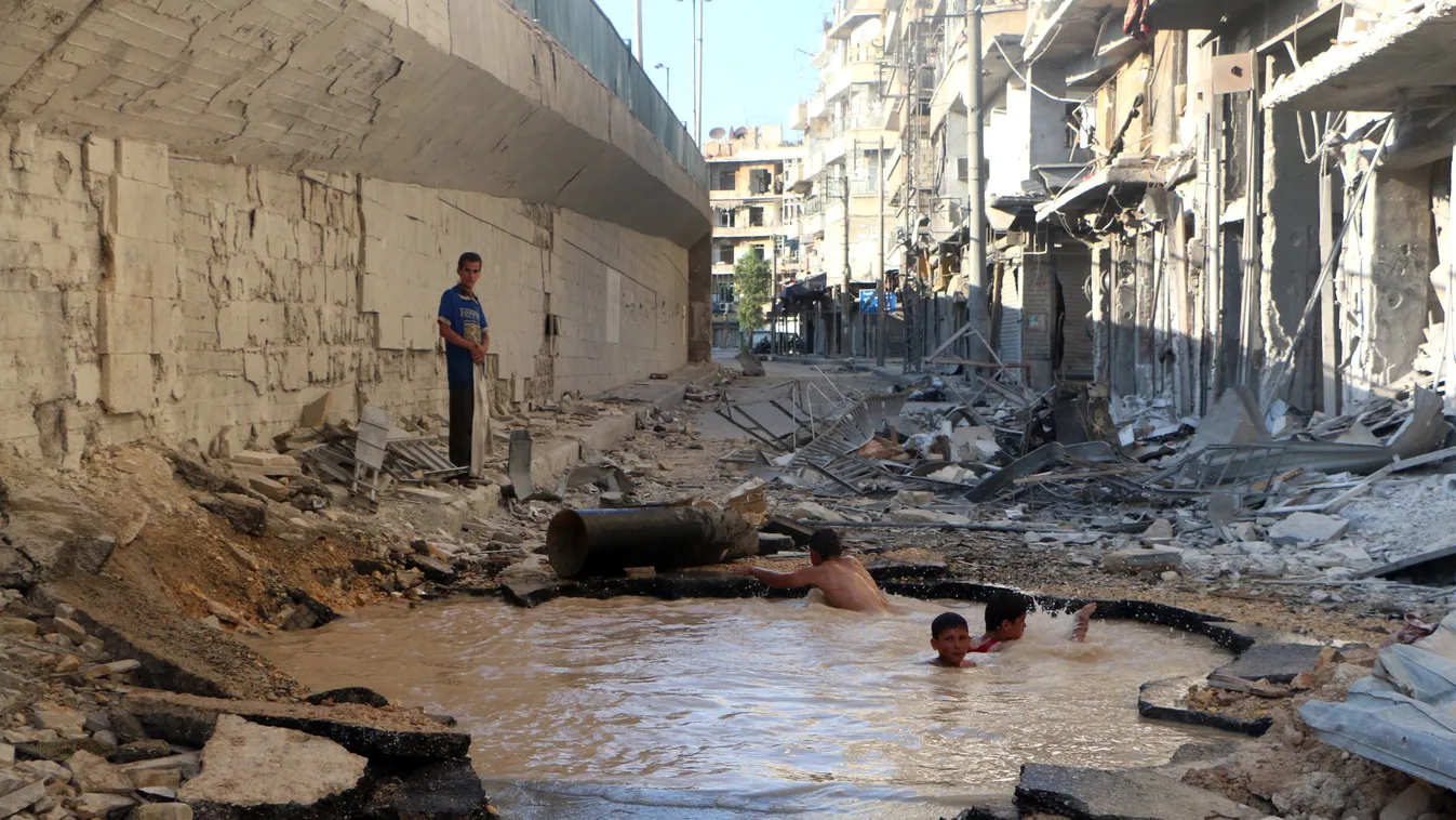 Syrian children play in a bomb crater flooded with water from a broken mains in the northern city of Aleppo, on July 10, 2014. Szíriai gyerekek 