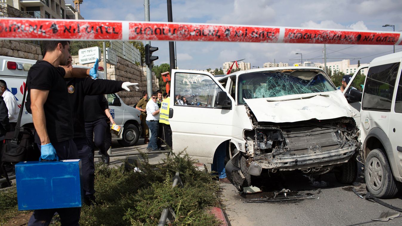 Israeli police and rescue workers inspect on November 5, 2014 the car a Palestinian man used to deliberately rammed it into a crowd of pedestrians in Jerusalem. One person was killed and at least nine others wounded. Police described the incident as a "hi