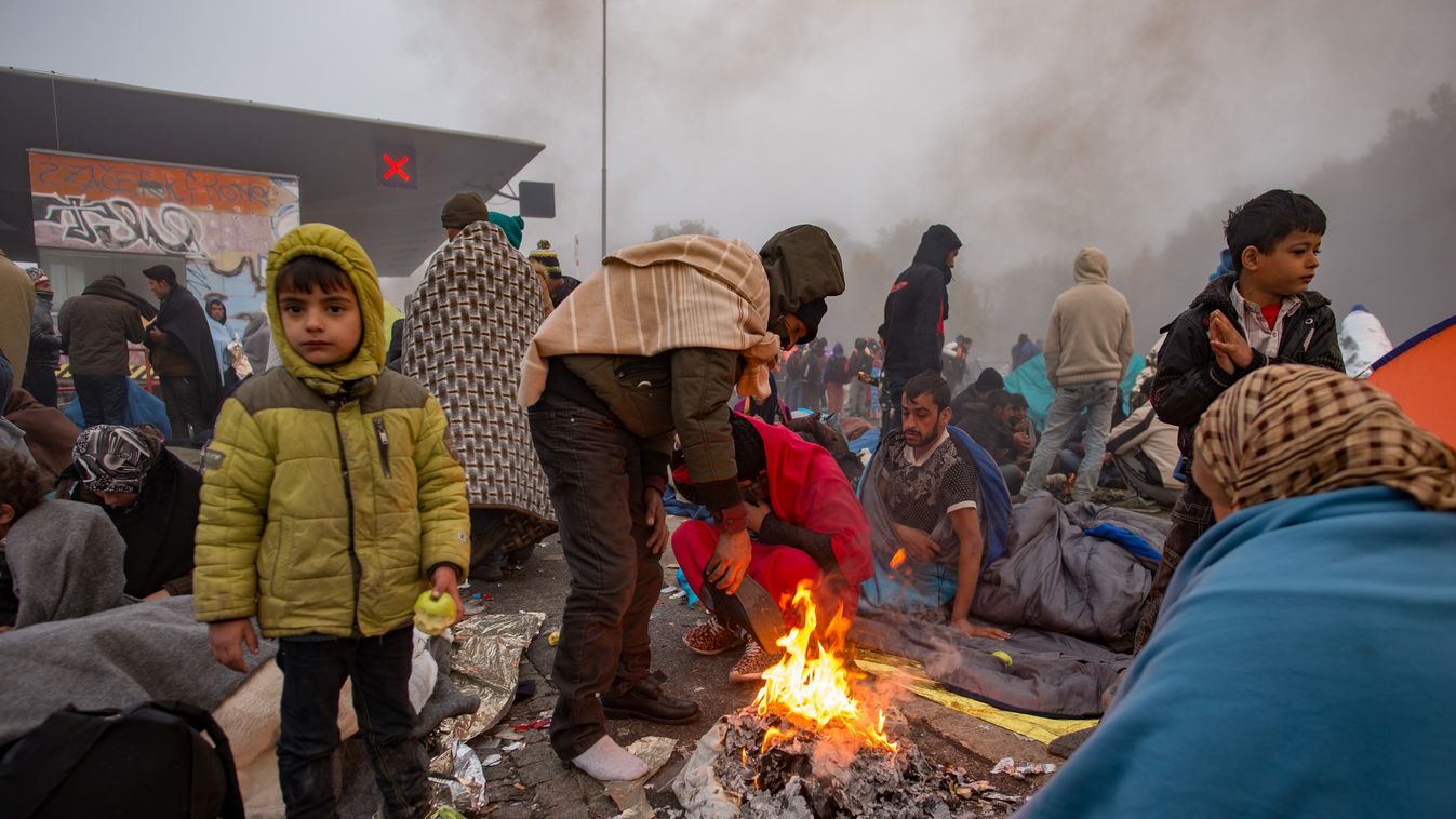 Migrants and refugees try to warm up as they wait for buses in Sentilj to cross the Slovenian-Austrian border into Spielfeld in Austria on October 24, 2015. Around 7,000 migrants have crossed into Austria from Slovenia since October 22, with some 4,500 st