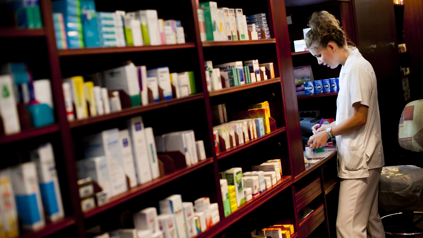 patika, gyógyszertár, .
Gyógyszerész áll egy budapesti gyógyszertár kiadóablakában 