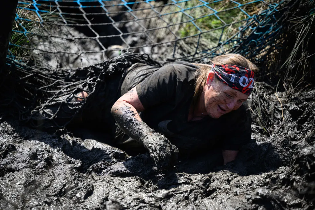 Horizontal OFFBEAT SPORTS EVENT MUD RACE GAMES AND RECREATION A competitor takes part in the Bog Commander endurance event near Ashbourne, in the Peak District moorlands, in northern England, on May 14, 2022. - The Bog Commander is a muddy obstacle race o