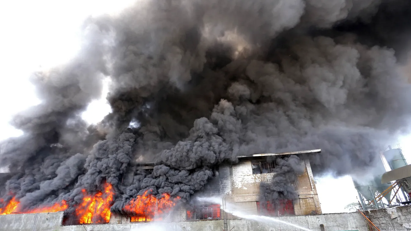 Philippine firemen try to put out a fire after it gutted a footwear factory in Valenzuela city suburban Manila on May 13, 2015. At least three people have been killed in a fire at a plastics factory in Manila, officials said on May 13, with fears that oth