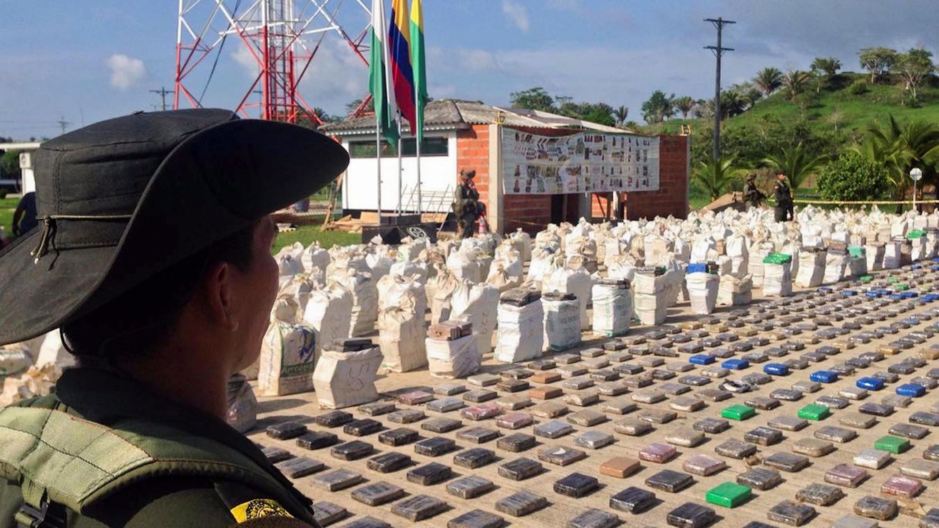 Horizontal Handout picture released by the Colombian police showing a Colombian police officer standing guard over eight tons of seized cocaine in Turbo, Antioquia department, on May 15, 2016.
General Jorge Nieto, the head of the Colombian police, said th