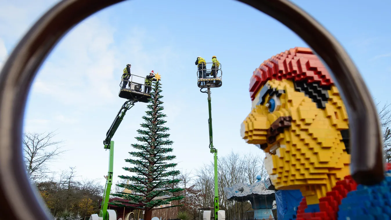 Legoland model maker Katrina James poses for pictures with a 3kg Lego star before placing it onto the top of a 8m tall Lego christmas tree during a photocall at Legoland Windsor Resort, west of London, on December 3, 2014. The tree, which is comprised of 