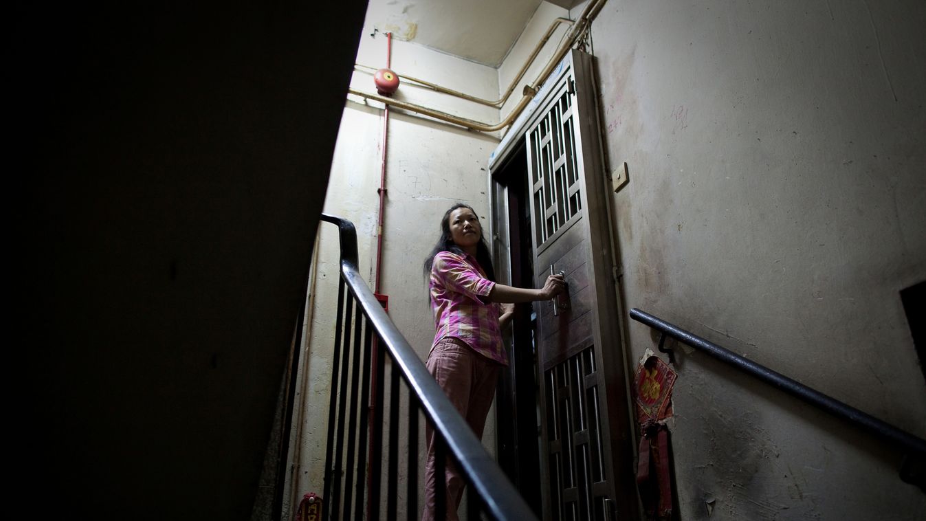 Horizontal Cubicle home resident surnamed Lau stands in her stairway in Hong Kong on May 20, 2011. Amid rising inflation many cage or cubicle home dwellers risk being subjected to rent increases despite paying a similar price per square foot as some of th