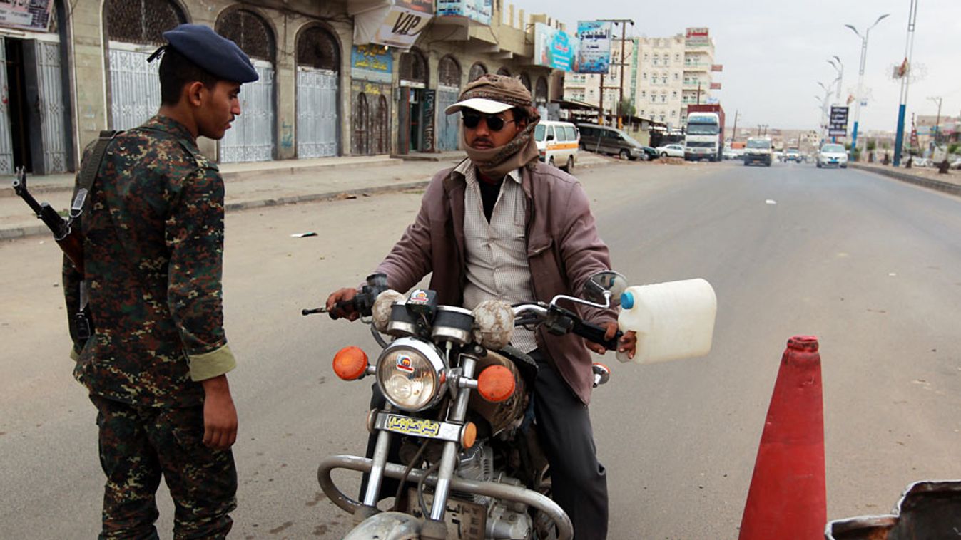 amerikai terrorriasztás, egy jemeni katona vizsgál át egy férfit, amerikai nagykövetségre vezető úton