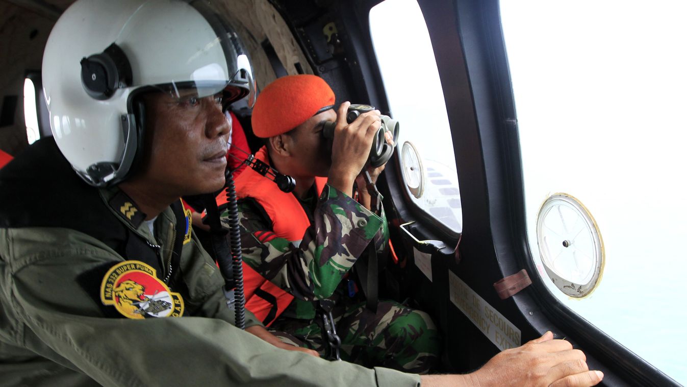 Indonesian crew members observe the surface of the sea during the search for AirAsia flight QZ8501 on board an aircraft over The Java Sea on January 1, 2015.   Indonesian recovery teams narrowed the search area for AirAsia Flight 8501, hopeful they were c