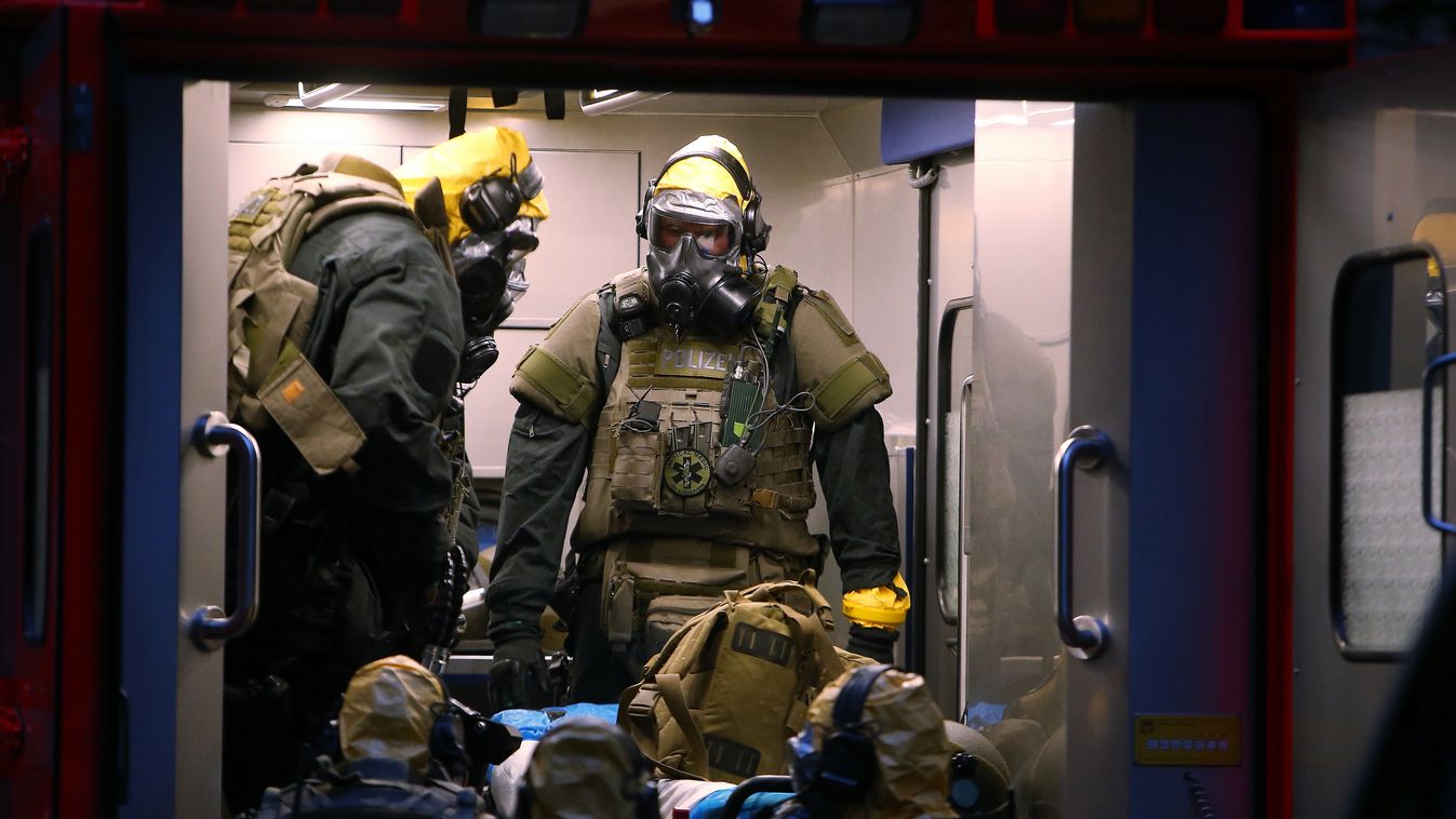 crime police Horizontal Police officers, including special forces wearing protective suits and gas masks stand in an ambulance next to a building on late June 12, 2018 in Cologne, where German police have arrested a Tunisian man after discovering "toxic s