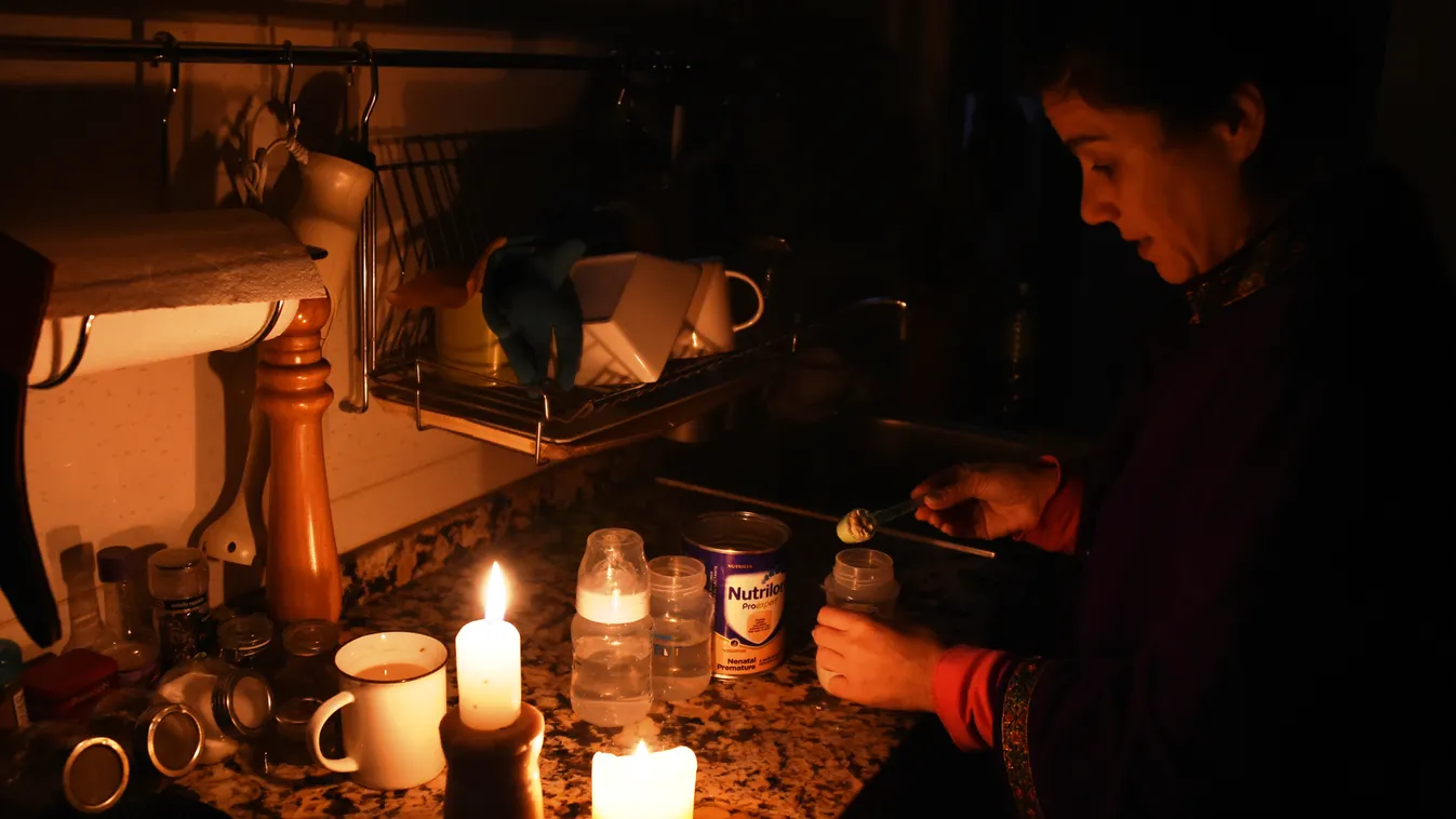 electricity TOPSHOTS Horizontal A woman prepares milk bottles using candles at her home in Montevideo on June 16, 2019 during a power cut. - A massive outage blacked out Argentina and Uruguay Sunday, leaving both South American countries without electrici