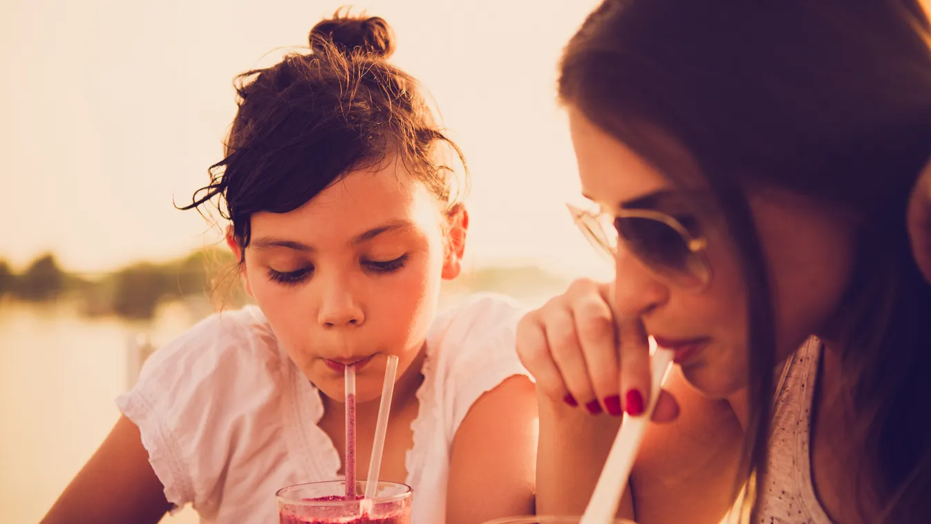 Mother and daughter drinking juice at cafe Beautiful Tubules Hair Bun Girls Women Females Two People Smoothie Facial Expression Drinking Glass Drinking Straw Adult Child Sitting Looking Drinking Fun Beauty Caucasian Ethnicity Togetherness Relaxation Enjoy