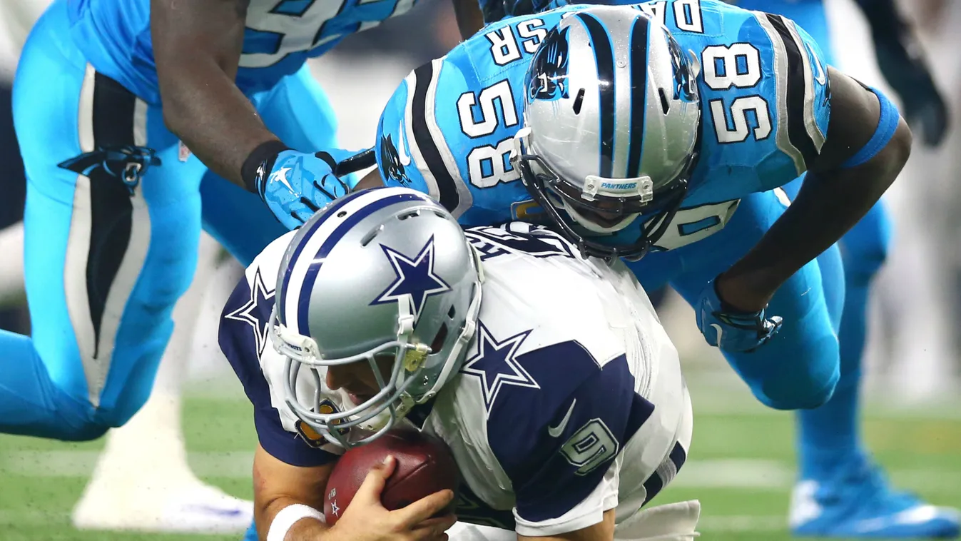 Tony Romo #9 of the Dallas Cowboys is taken down by Thomas Davis #58 and Mario Addison #97 of the Carolina Panthers in the third quarter at AT&T Stadium on November 26, 2015 in Arlington, Texas. 