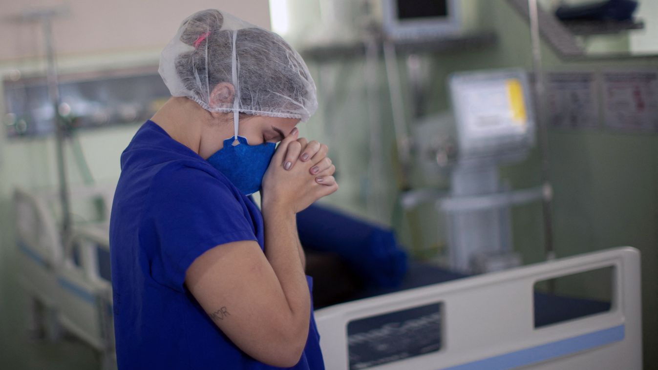 hospital health pandemic virus music religion Horizontal A hospital worker prays as health workers from the Portuguese charity hospital in Belem, Para State, Brazil, sing and pray for colleagues and COVID-19 patients inside the hospital wards and ICU area