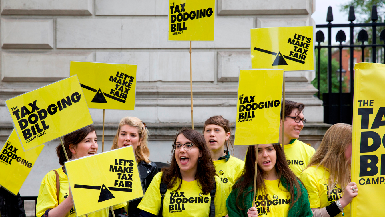 Protestors hold placards as they demonstrate against 'Tax Dodging' outside the gates to Downing Street in London on May 9, 2015, following the UK general election on May 7. Britain awoke to a new political landscape after a shock election victory for Prim