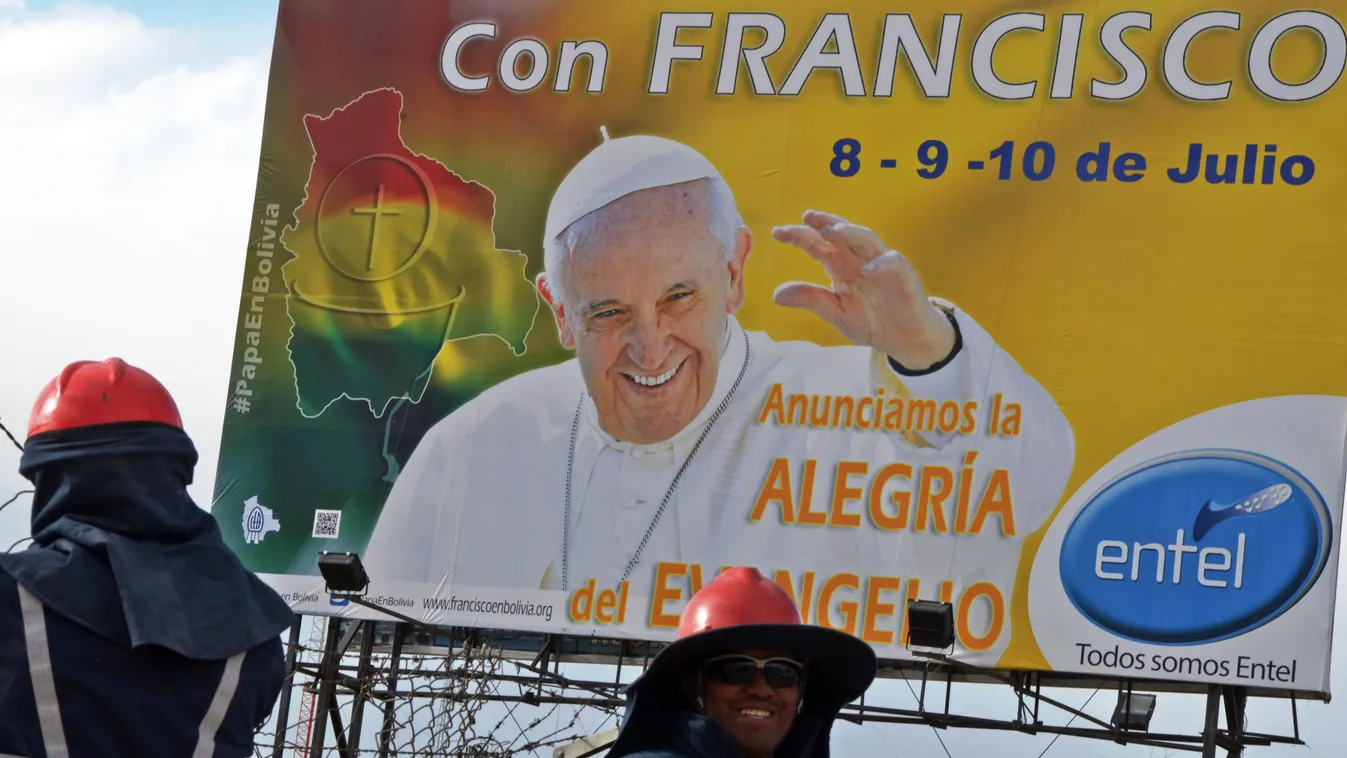 Municipal workers are seen in front of a banner of Pope Francis in El Alto, Bolivia on July 3, 2015. Pope Francis will make a three-day visit to Bolivia next week. AFP PHOTO/Aizar Raldes 