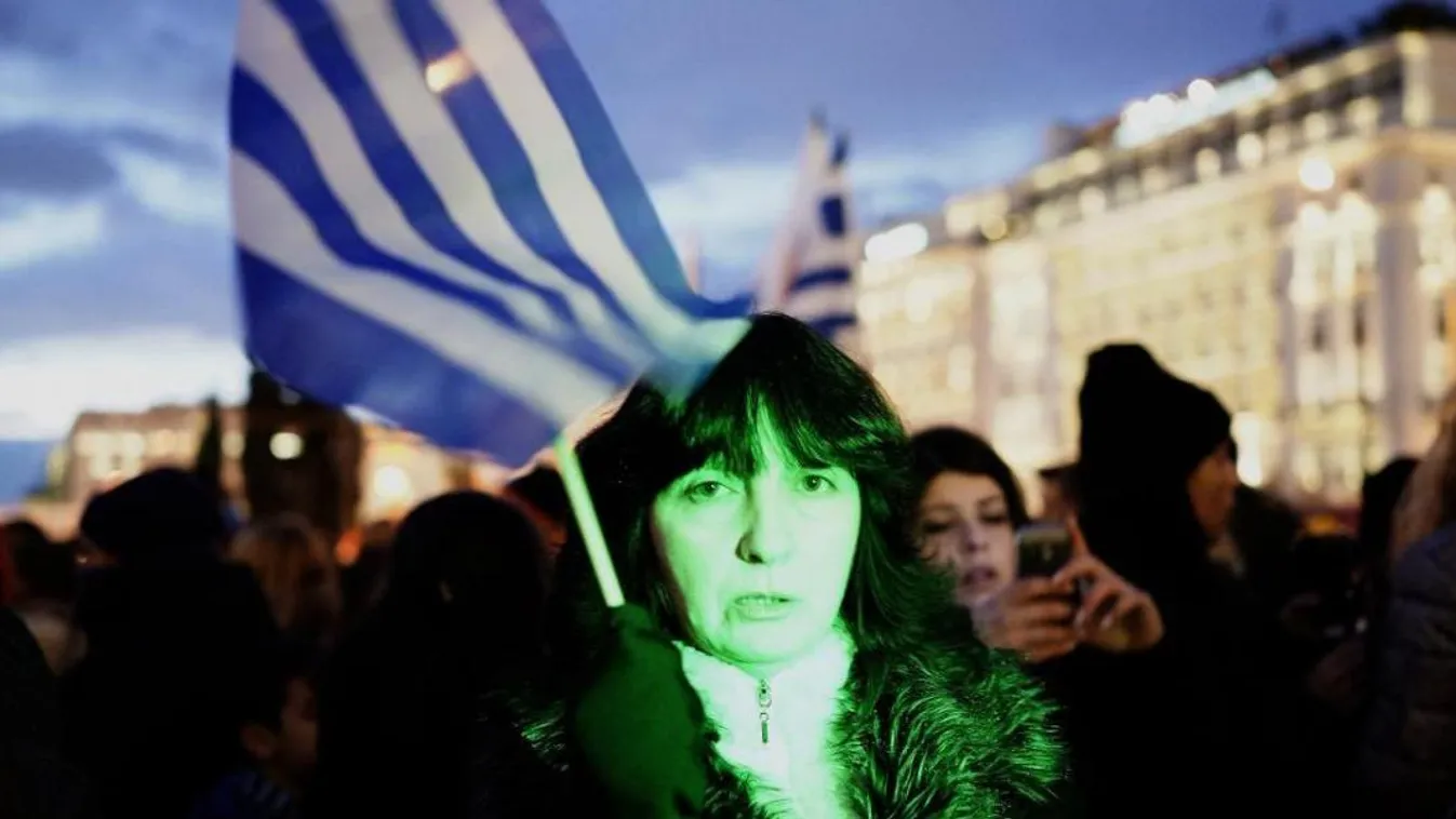 Egy görög zászlót tartó nő a kormányzati megszorításokat ellenző tüntetésen (2015. február 11.) 