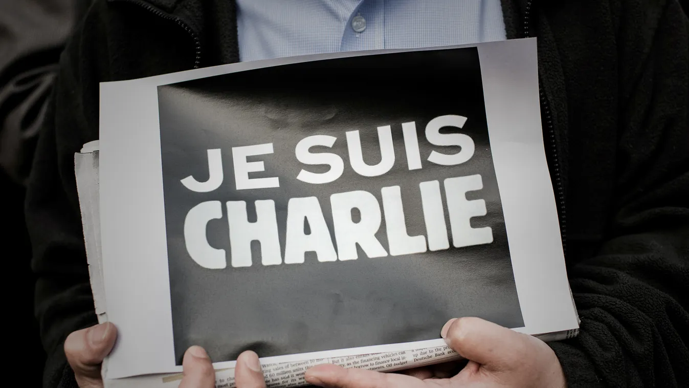 HORIZONTAL AFTERMATH OF THE TERRORISM POSTER SLOGAN RALLY ASIA NEWSPAPER VERY CLOSE-UP TERRORISM A man displays a placard in solidarity with the victims of the shooting at the Paris office of the satirical newspaper Charlie Hebdo by three gunman that took
